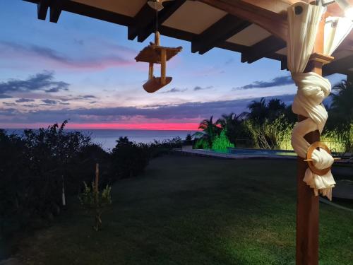 a view of the ocean from the backyard at dusk at Chambre d'hotes "Villa Rayon Vert" in Deshaies