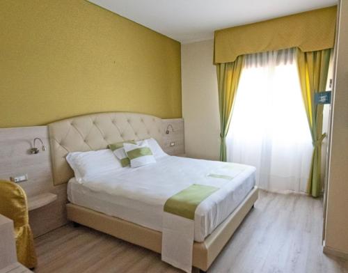pokój hotelowy z łóżkiem i oknem w obiekcie Hotel Castello Artemide Congressi w mieście Castel San Pietro Terme