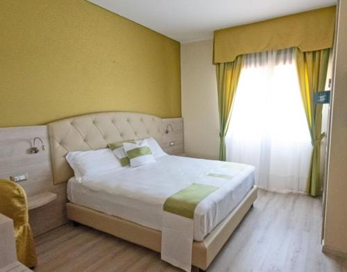 Giường trong phòng chung tại Hotel Castello Artemide Congressi