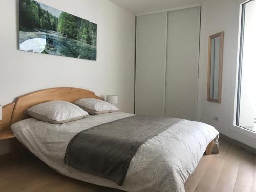 a bedroom with a bed and a painting on the wall at la providence in Annecy