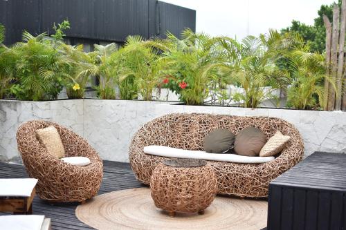two wicker chairs sitting on top of a patio at Che Suites Tulum in Tulum