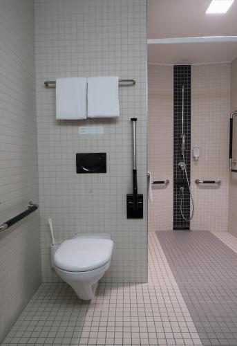 a bathroom with a toilet and a shower at Hotel Sempachersee in Nottwil