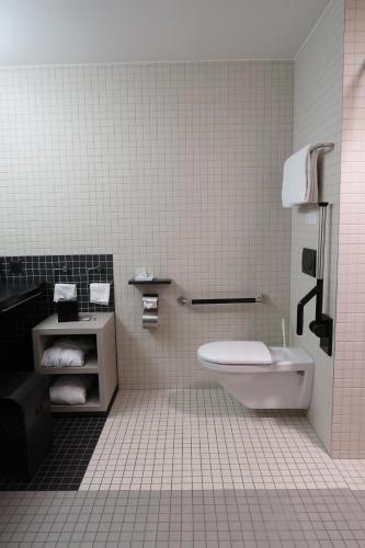 a bathroom with a toilet and a sink at Hotel Sempachersee in Nottwil