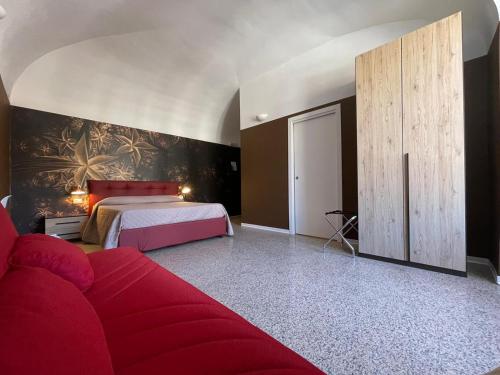 a bedroom with a bed and a red couch at CconfortHotels R&B Central Rooms in Bari