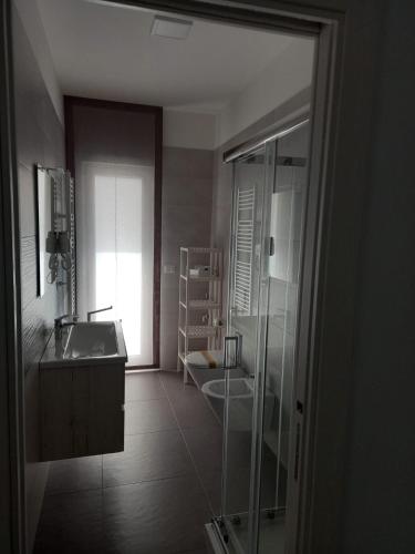 a bathroom with a glass shower and a sink at Casa MIMI Aparthotel in Matera