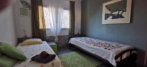 a small bedroom with two beds and a window at Casafuera in Pals