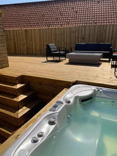 a jacuzzi tub on a deck with a patio at luksus spahus i skagen in Skagen