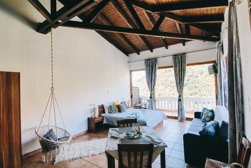 a living room with a couch and a swing at Lefteris Rooms in Kámbos