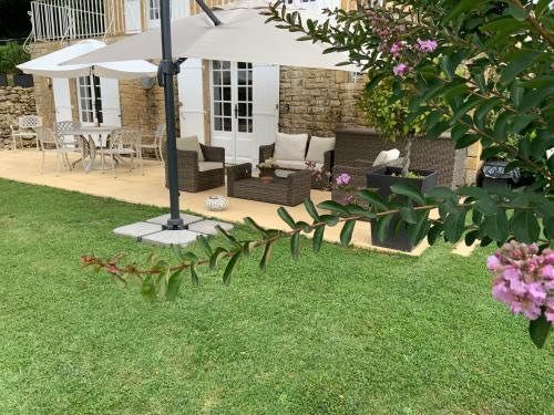 een tuin met een patio en een parasol bij Amity. Exclusive poolside garden apartment in Sarlat-la-Canéda