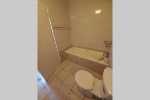 a bathroom with a toilet and a bath tub at Margate Boulevard - Superb Secure Apartment in Margate