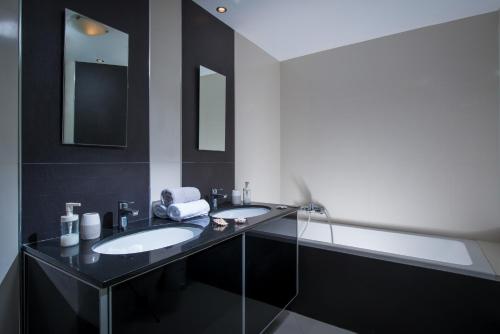 a black bathroom with two sinks and a mirror at Coast Suite-Luxury Central Beach House in Hersonissos