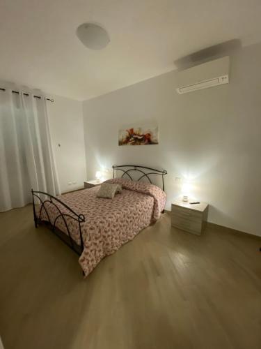 a bedroom with a bed and a table with lights at Fringiulì House in Trevignano Romano