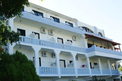 a large white building with balconies on it at Lofos Hotel in Plakias