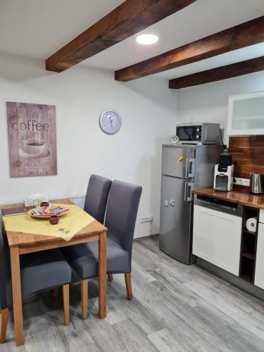 eine Küche mit einem Holztisch und Stühlen sowie einem Kühlschrank in der Unterkunft Haus Schneider in Kappel-Grafenhausen