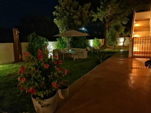 a patio at night with flowers in a yard at Sirios in Acharavi