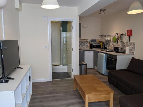 a living room with a couch and a kitchen at The Ramblers' Rest - Princetown in Princetown