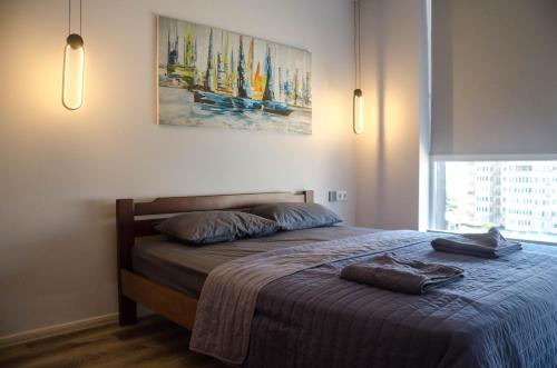 a bedroom with a bed with two towels on it at Kokos Avenue Loft Apartments in Yuzhne
