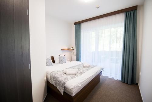 sypialnia z łóżkiem i dużym oknem w obiekcie Galeria Apartments w Demianowskiej Dolinie