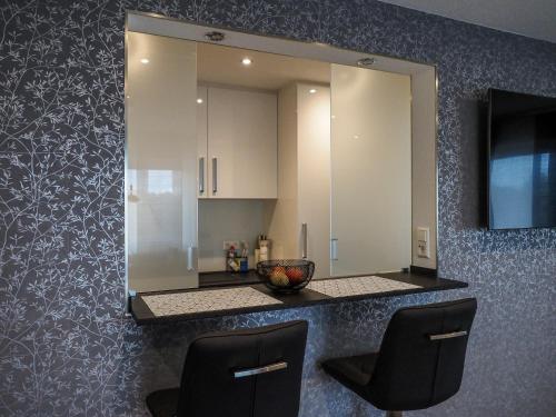 a mirror on a wall with two chairs in a kitchen at Ferienwohnung Langlitz in Rust