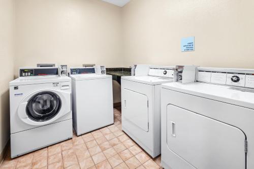 a laundry room with three washing machines and a washer and dryer at Holiday Inn Express Portland SE - Clackamas Area by IHG in Gladstone