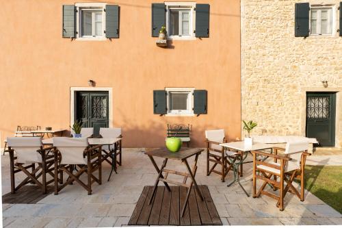 a patio with tables and chairs in front of a building at The Merchants House in Perítheia