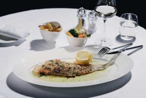 a plate of fish with a lemon on a table at Residence Hotel in Vaduz