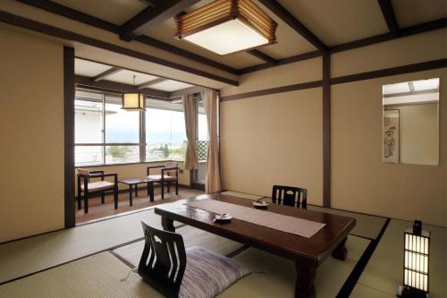 a dining room with a table and chairs and a window at Kami no yama Azumaya in Kaminoyama