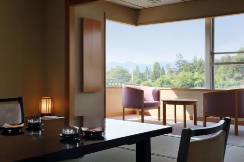 a dining room with a table and chairs and a large window at Kami no yama Azumaya in Kaminoyama