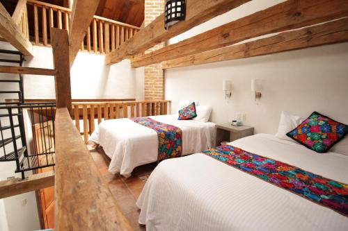 a room with two beds and a staircase at Hacienda Molino Santo Domingo in San Cristóbal de Las Casas
