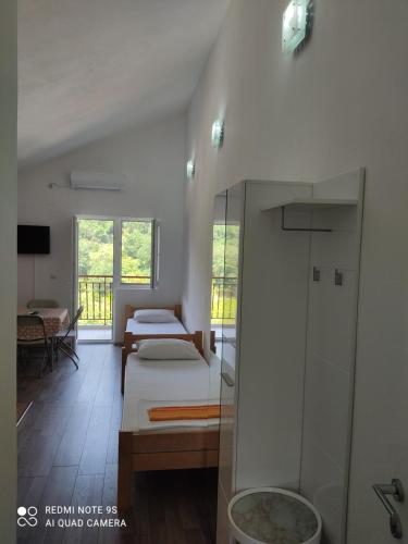 a room with two beds and a balcony at TopHoliday in Herceg-Novi