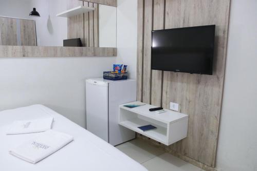 a room with a refrigerator and a tv on a wall at Imperial Hotel By Nobile in Juazeiro do Norte