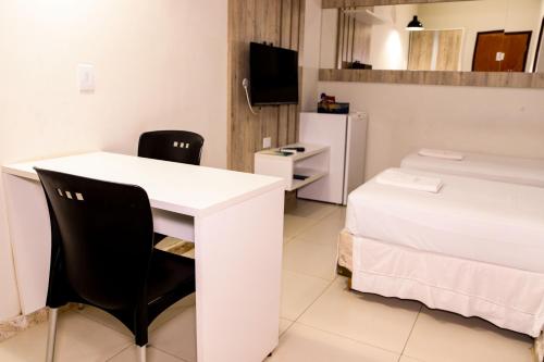 a room with a white table and chairs and a bed at Imperial Hotel By Nobile in Juazeiro do Norte