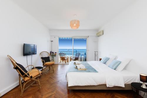 a bedroom with a bed and a view of the ocean at Palais des Iles YourHostHelper in Cannes