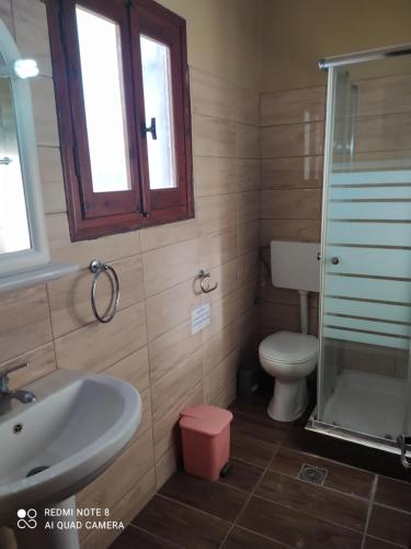 a bathroom with a sink and a toilet and a glass shower at EKTOR APARTMENTS @SWIMMING POOL in Sidari