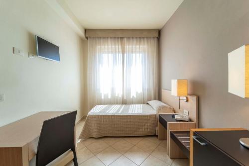 a hotel room with a bed and a window at Hotel San Giuan in Alghero