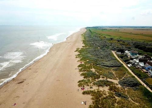 an aerial view of a beach with houses and the ocean at Luxury Holiday Home in Anderby Creek in Anderby