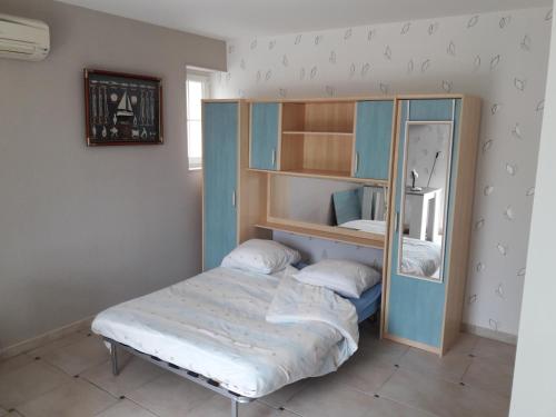 - une petite chambre avec un lit et un miroir dans l'établissement Logis de LANGE studio 2 p, à Saint-Hilaire-la-Palud