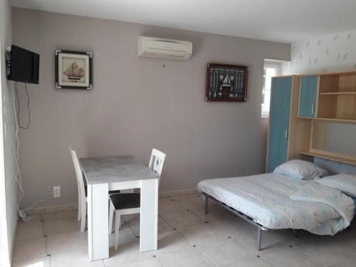 a room with a table and a bed and a desk at Logis de LANGE studio 2 p in Saint-Hilaire-la-Palud