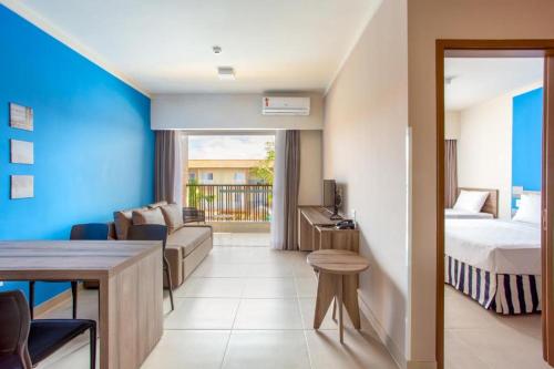 pokój hotelowy z łóżkiem i kanapą w obiekcie Apartamento Ondas Resort w mieście Porto Seguro