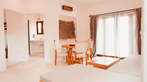 Brisas de ZicatelaにあるCasa Kuaaの白いリビングルーム(テーブル、椅子付)