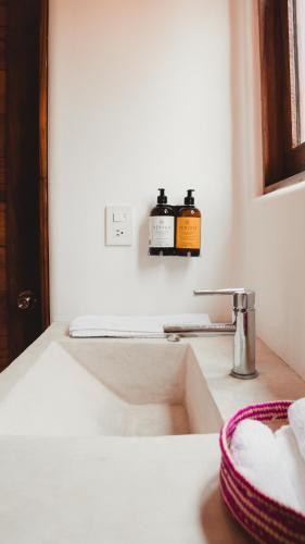 a bathroom sink with two bottles of soap on a counter at Casa Kuaa in Brisas de Zicatela