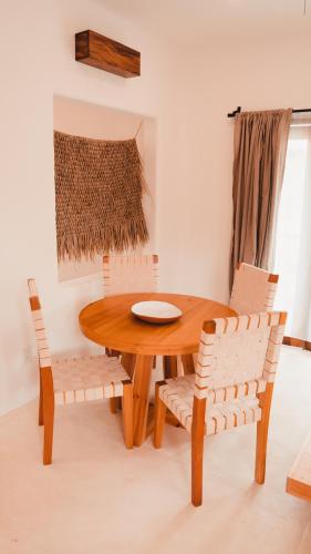 a dining room with a wooden table and chairs at Casa Kuaa in Brisas de Zicatela