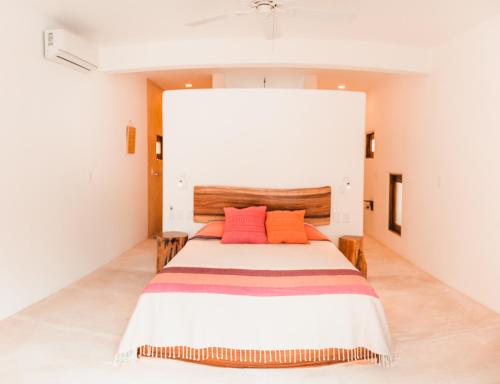 a bedroom with a bed with two orange pillows at Casa Kuaa in Brisas de Zicatela