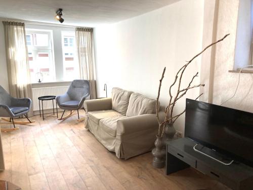 uma sala de estar com um sofá e uma televisão de ecrã plano em LA PETITE MAISON Fachwerkhaus am Rande des Sauerlandes in Warburg em Warburg