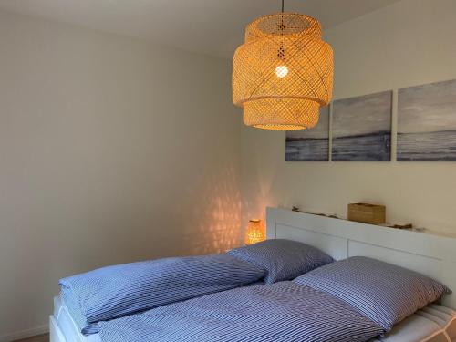 una camera con letto e lampadario di Wohnen am Südstrand - Ferienwohnung 0 5 a Wyk auf Föhr