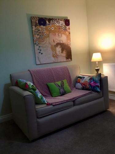 a couch with pillows on it in a living room at The Glen Mona Hotel in Maughold