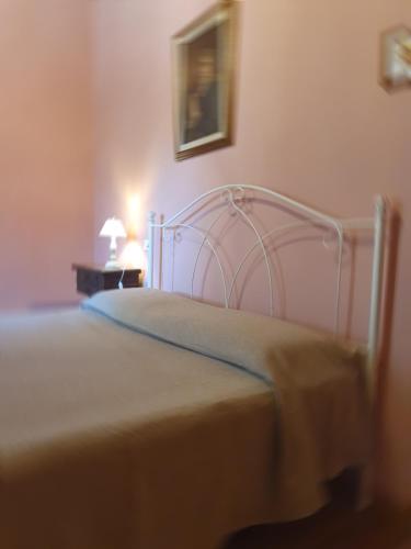 a bedroom with a white bed with a yellow blanket at Casa Giogo in Arezzo