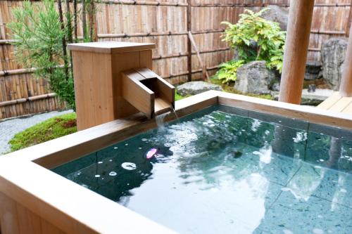 a koi pond with a fountain in a backyard at Ryokan Shinsen in Takachiho