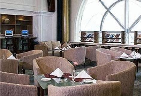 a dining room with tables and chairs and a restaurant at Swissôtel Hefei Grand Park in Hefei