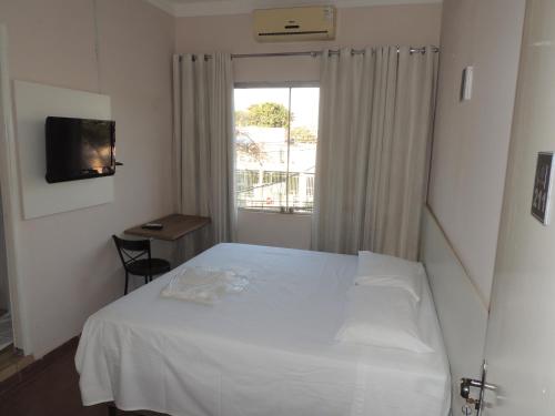 a bedroom with a white bed and a window at Hotel Belvedere Araras - Fácil Acesso Hospital São Leopoldo e Faculdades in Araras
